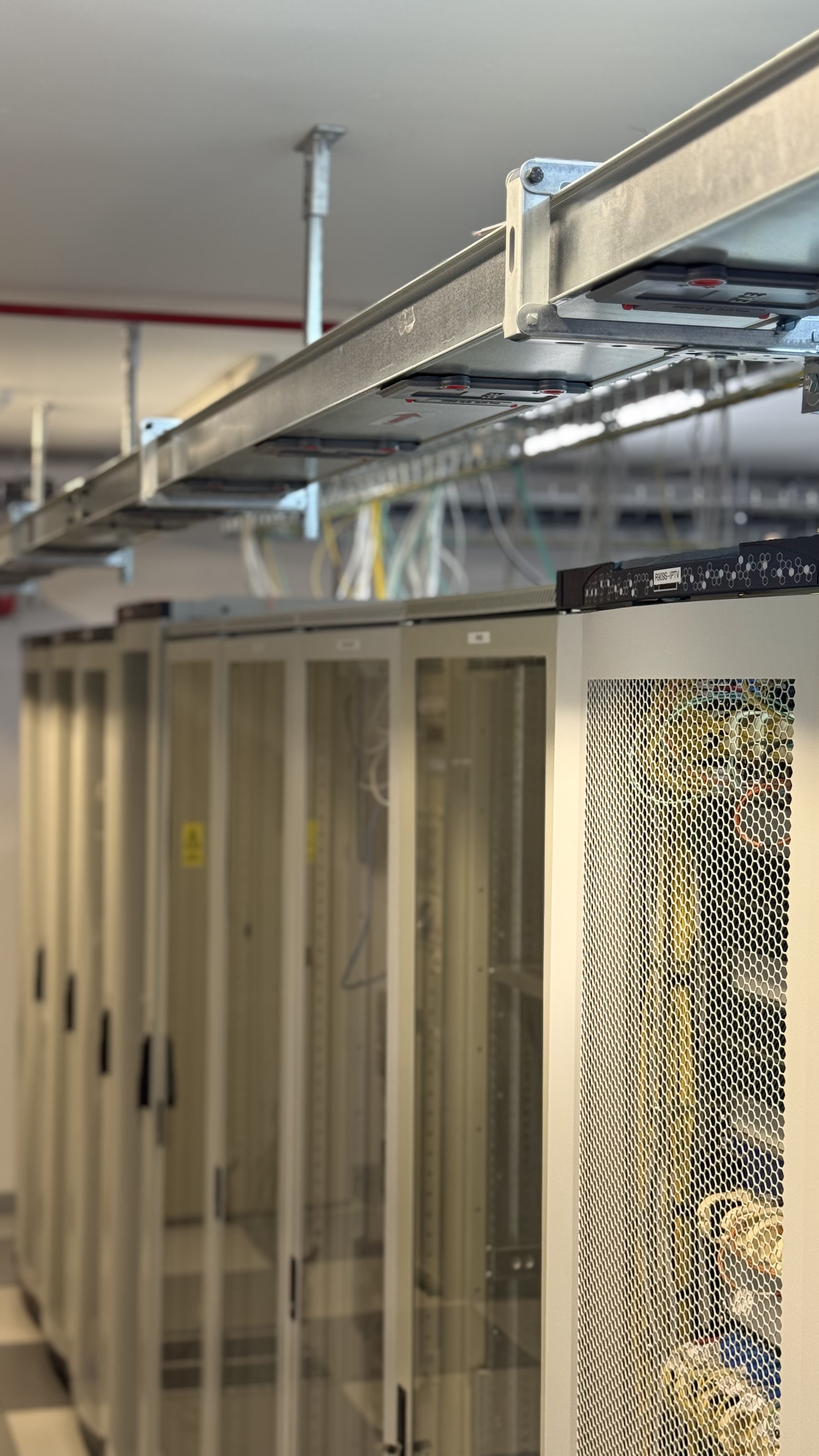 Sala de echipamente din Data Center-ul iNES, cu rackuri și traseele de cabluri
